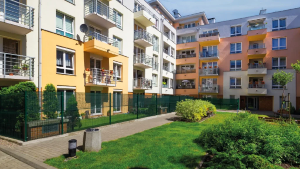 Et moderne leilighetskompleks med fargerike fasader i nyanser av gult og rosa, bygningene har flere balkonger med utsikt over en godt vedlikeholdt gresskledd gårdsplass. Ta en rolig spasertur på den asfalterte gangveien og nyt den livlige atmosfæren – perfekt for enhver fagdag-retrett.